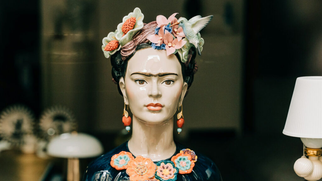 Frida Kahlo bust glowing in a shop window, vibrant and magnetic